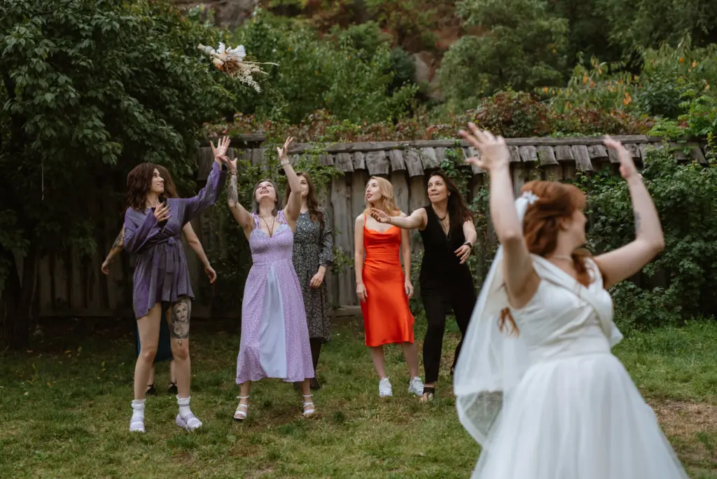 Bride Tossing the Bouquet to Her Excited Bridesmaids