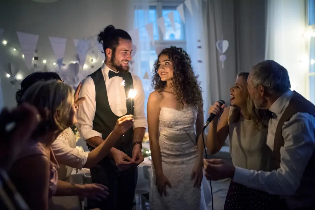Newlyweds Enjoying a Sparkler Celebration Surrounded by Singing Guests