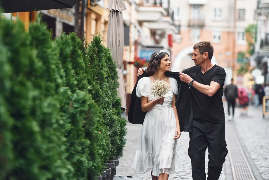 Beautiful bride with his fiancé is celebrating wedding outdoors.