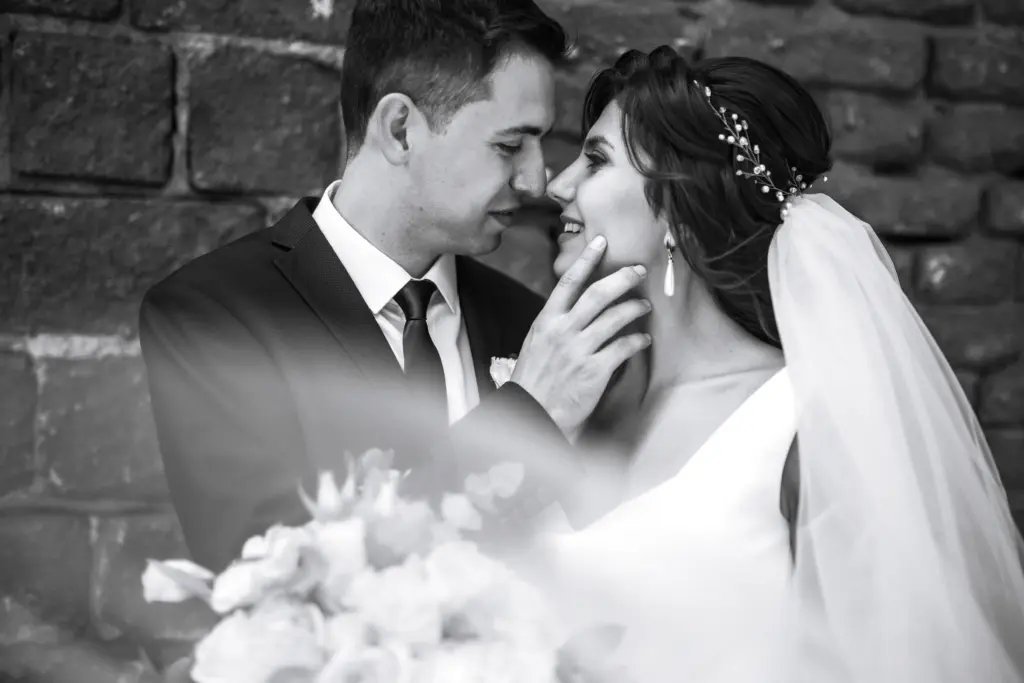 Black, white photo of cheerful emotional newlyweds who enjoy each other.