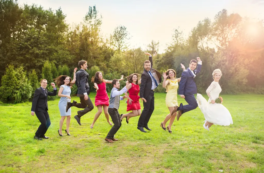 Newlywed Couple Leading a Lively Jump with Their Friends