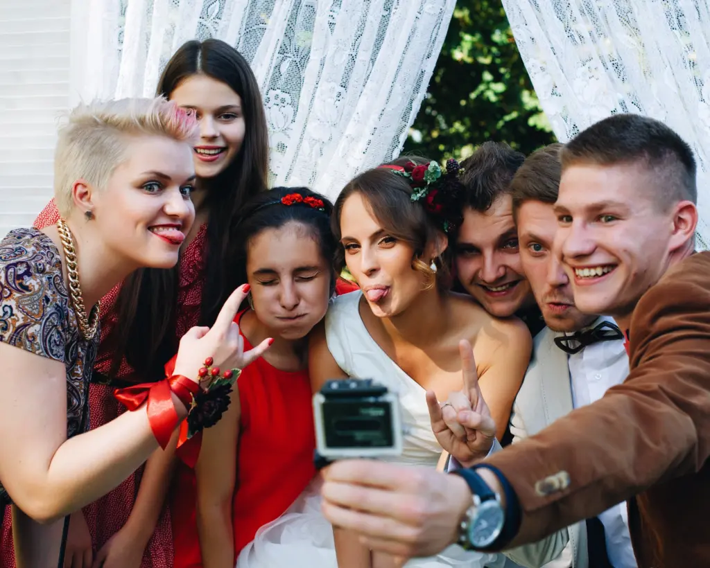 Group of millennial friends funny posing in camera go pro at wedding