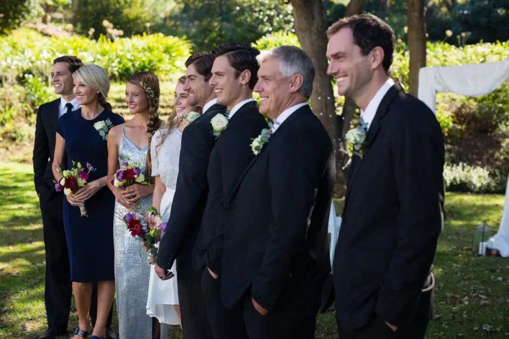 Happy bride and groom standing with guests